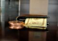 brown leather bifold wallet with banknotes sticking out