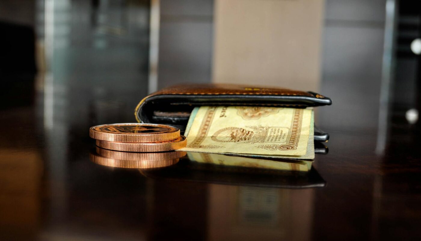 brown leather bifold wallet with banknotes sticking out