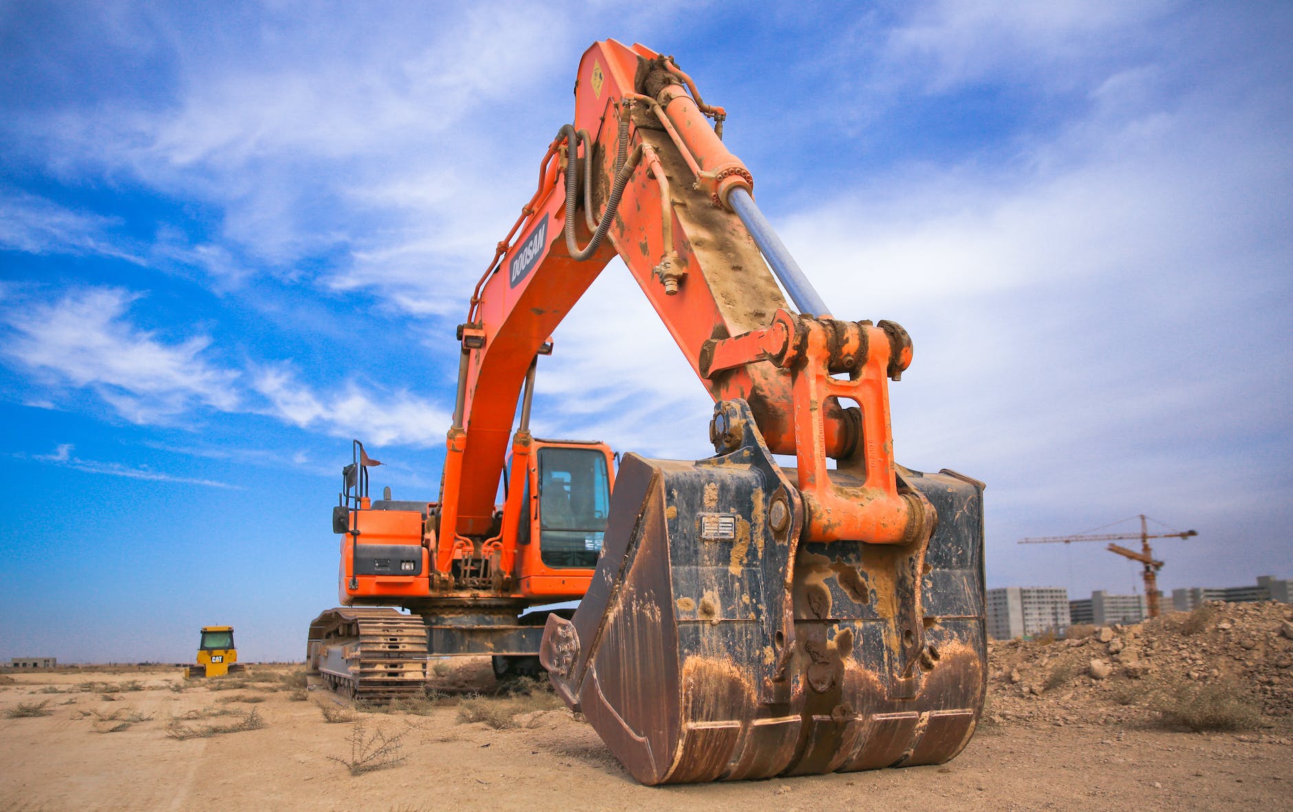low angle photography of orange excavator under white clouds, county auction