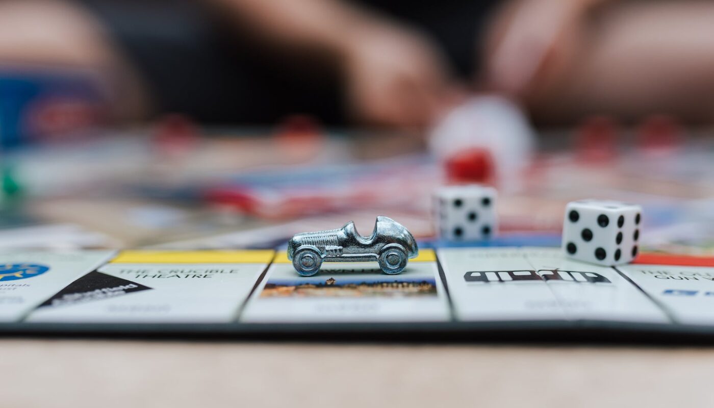 miniature toy car on top of monopoly board game