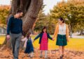 a happy family walking at the park together while holding hands