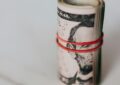 roll of american dollars tightened with red band