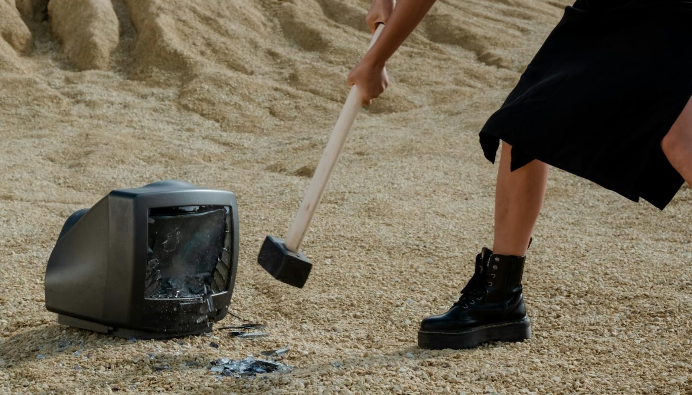 a person in black leather boots holding a mallet