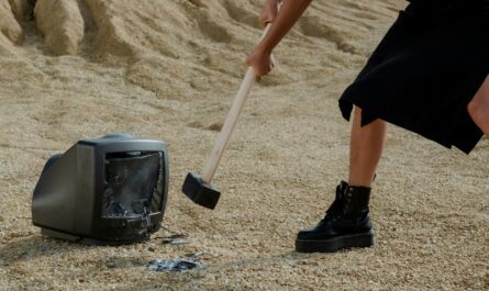 a person in black leather boots holding a mallet