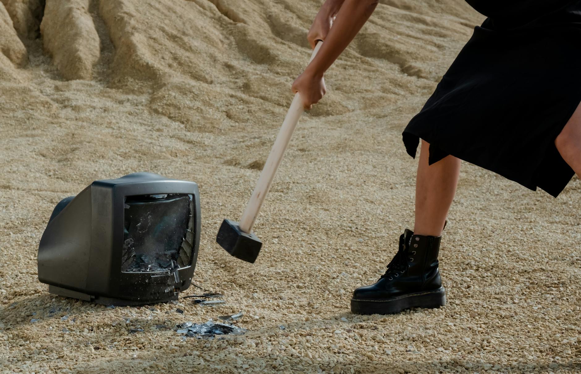 a person in black leather boots holding a mallet